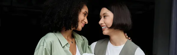 Two women, dressed in business attire, look at each other lovingly in an office setting. — Stock Photo