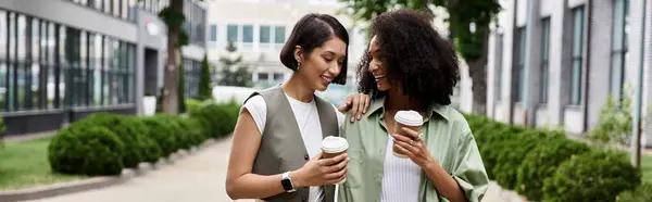 Lesbisches Paar posiert im Freien und lächelt mit Kaffee. — Stockfoto