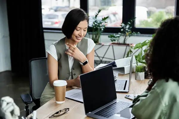 Two women, partners in both life and business, collaborate on a project at their desk. — Stock Photo