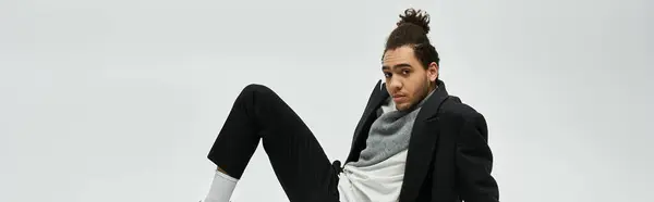 A stylish African American man poses in trendy elegant attire against a grey background. — Stock Photo