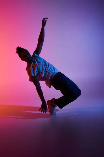 An African American male dancer showcases his energy and fluidity against a vibrant backdrop. — Stock Photo