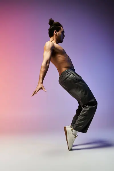 An African American man performs a dynamic dance move against a colorful gradient backdrop. — Stock Photo