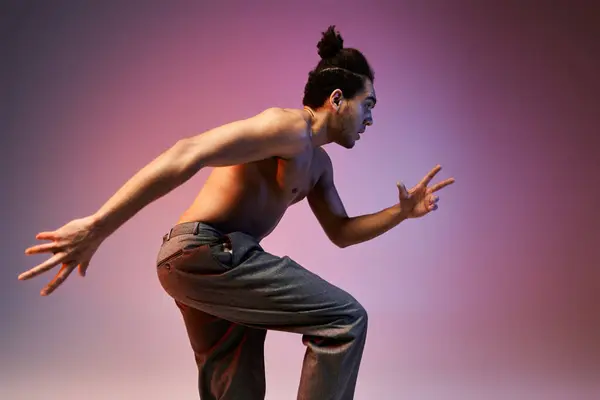 A young African American man dances against a colorful, gradient backdrop, showcasing dynamic movement. — Stock Photo
