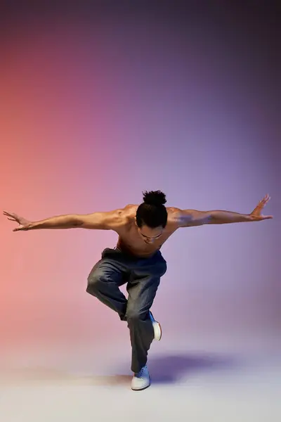 A young African American man dances on a colorful gradient background. — Stock Photo