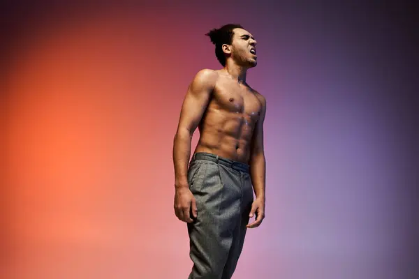 An African American man in grey pants dances against a colorful gradient background. — Stock Photo