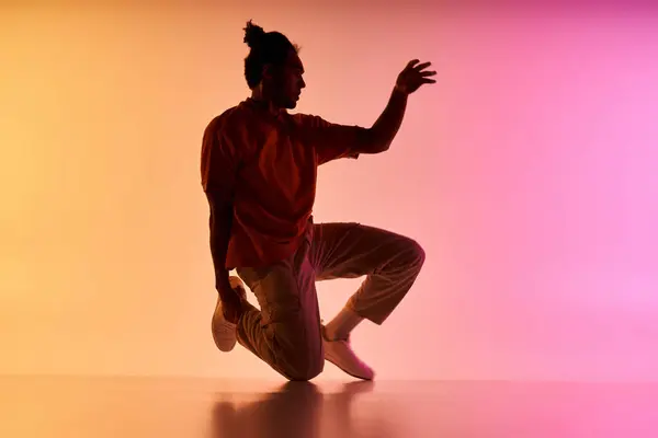 A young African American man dances against a colorful gradient background. — Stock Photo