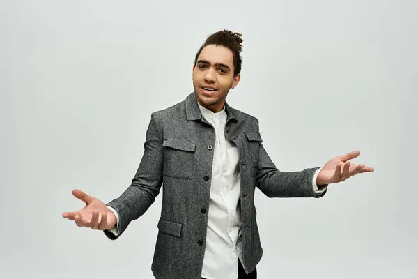 A stylish African American man in a grey coat poses with a relaxed and confident expression against a white backdrop. — Stock Photo