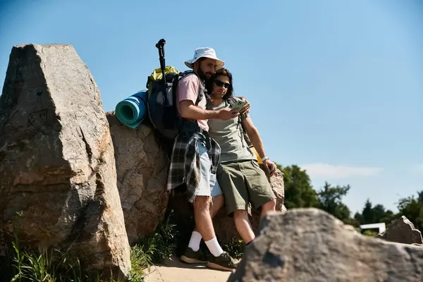 Dois jovens, um casal gay, caminham e aproveitam o verão ao ar livre, parando para olhar para um mapa e planejar seus próximos passos. — Fotografia de Stock