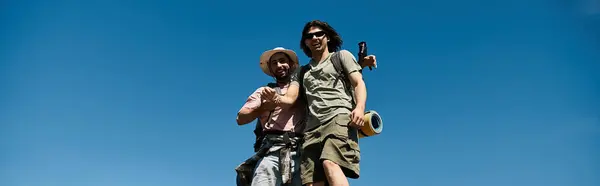 Um jovem gay casal sorrisos feliz enquanto caminhadas no deserto no um ensolarado verão dia. — Fotografia de Stock