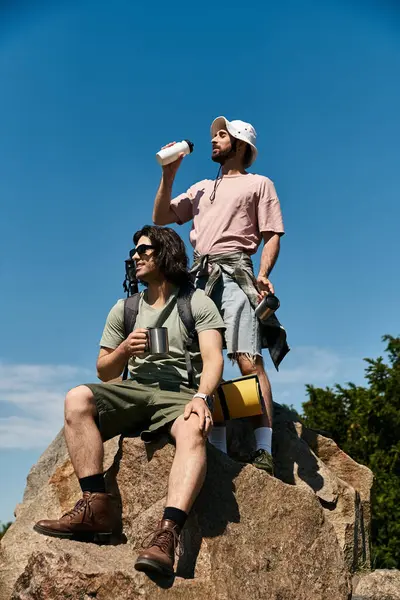 Zwei junge Männer, ein schwules Paar, wandern an einem sonnigen Sommertag durch die Wildnis. — Stockfoto