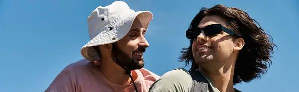 Two young men hike together in a sunny, outdoor setting. They appear to be enjoying each others company. — Stock Photo