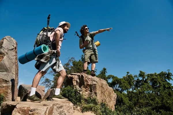 A young gay couple hikes through nature on a sunny summer day, showcasing their love and connection in the wilderness. — Stock Photo