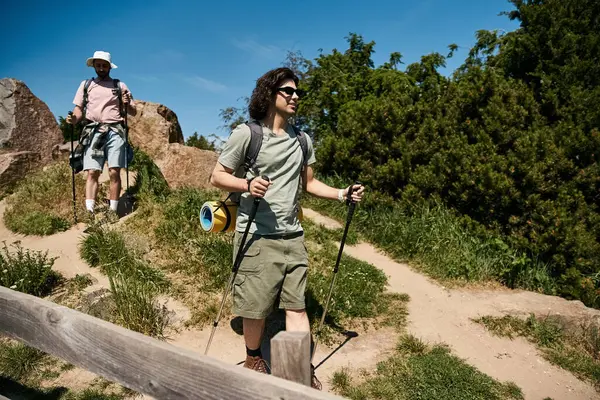 Dois jovens, um casal gay, caminham juntos no deserto em um dia de verão. — Fotografia de Stock