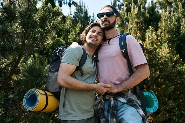 A young gay couple hikes through a lush forest, enjoying the summer scenery and their love for each other. — Stock Photo
