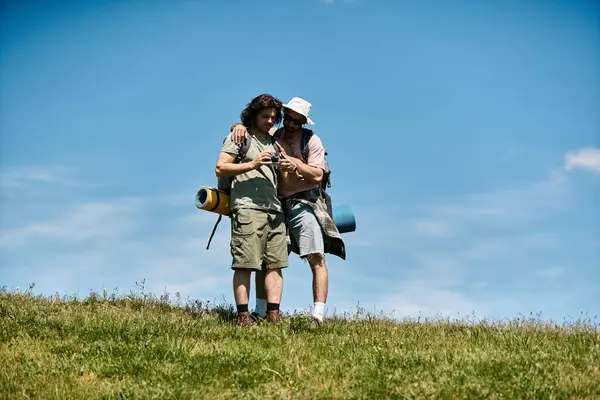 A young gay couple enjoys a summer hike in the wilderness, embracing the beauty of nature together. — Stock Photo