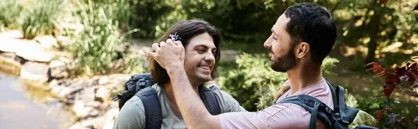 A young gay couple smiles and enjoys their hike through lush greenery on a sunny day. — Foto stock