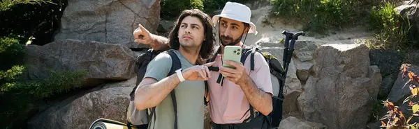 Two young men, a gay couple, hike through a rocky wilderness area on a sunny summer day. — Stock Photo
