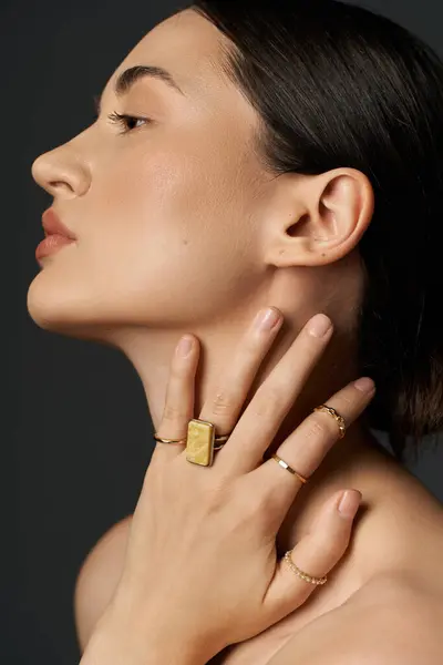 Un primo piano di una mano di giovani donne che mostrano anelli d'oro su uno sfondo scuro. — Foto stock