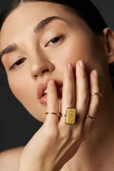 A close-up shot of a young womans hand, showcasing her golden rings against a dark background. — Stock Photo