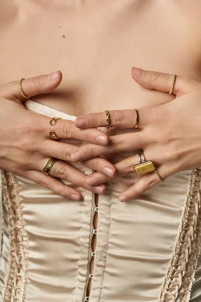 A young woman displays her golden rings on a dark background, showcasing her love for jewelry and fashion. — Stock Photo