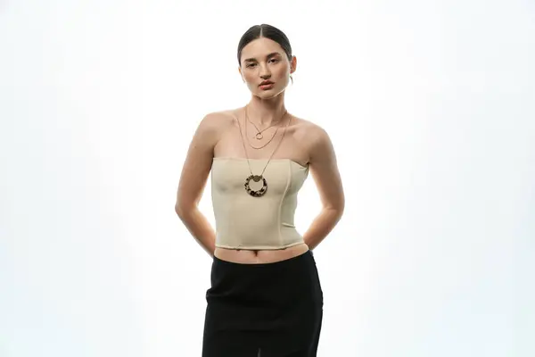 A young brunette woman in a white top shows off her beautiful jewelry against a white background. — Stock Photo