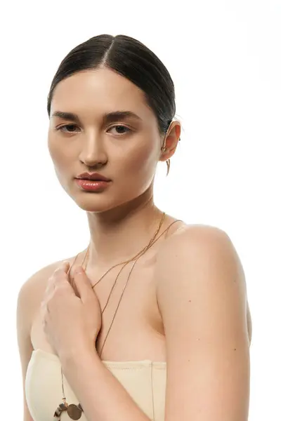 A young brunette woman with flawless skin showcases exquisite jewelry against a white background. — Stock Photo