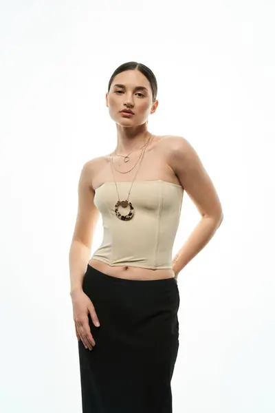 A young woman with dark hair and a captivating gaze showcases her elegant jewelry while dressed in a simple yet stylish outfit. — Stock Photo