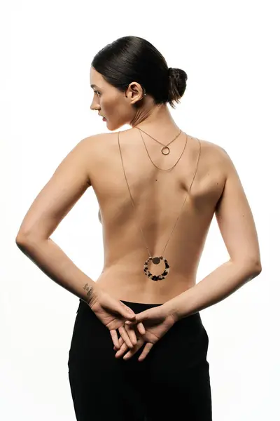 Une jeune femme avec des modèles de cheveux foncés bijoux stratifiés avec un morceau de déclaration sur le dos. — Photo de stock