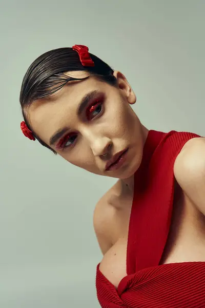 Una bella giovane donna con i capelli corti indossa un vestito rosso in un ambiente da studio. — Foto stock