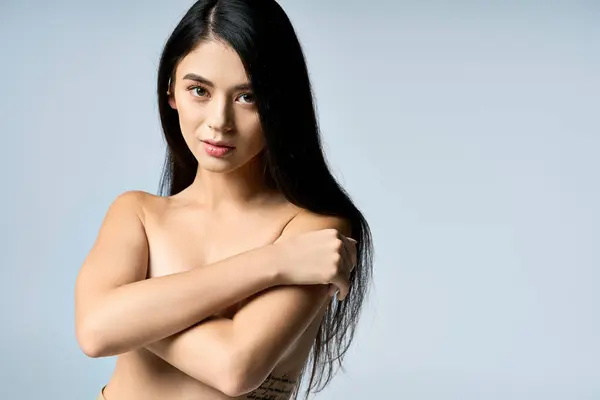 A young woman with long black hair poses confidently, showcasing her beauty and natural grace. — Stock Photo