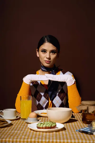 A young woman in a stylish outfit poses at a breakfast table. — Stock Photo