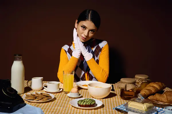 Модная молодая женщина позирует за столом, наслаждаясь вкусным завтраком. — стоковое фото