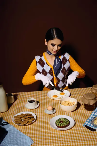 Uma mulher elegante em um colete estampado desfruta de um café da manhã com ovos, donuts e biscoitos. — Fotografia de Stock