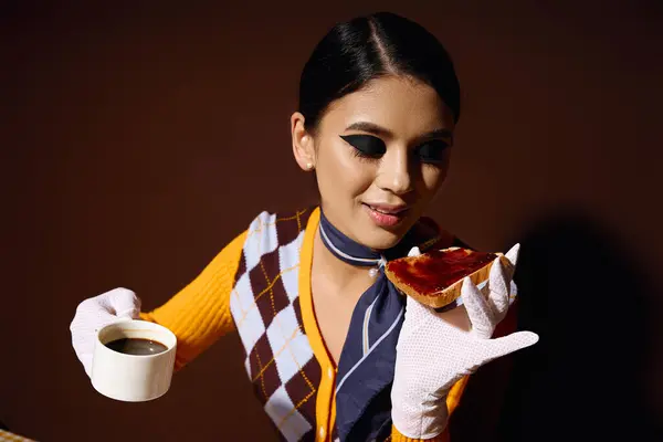 A young woman in a stylish outfit enjoys a cup of coffee and a piece of toast. — Stock Photo
