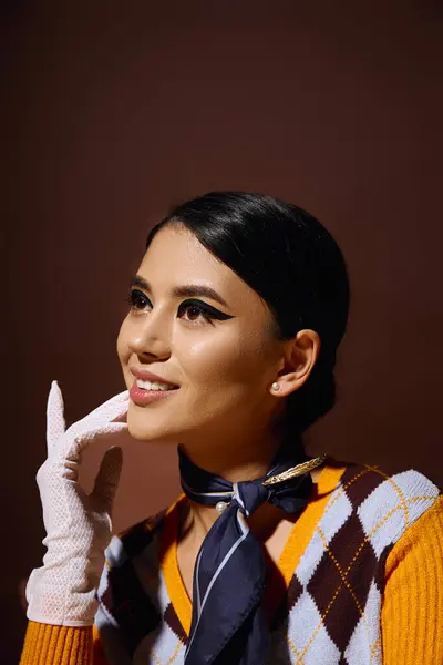 Eine junge Frau im stylischen Outfit posiert anmutig und blickt nach oben. — Stockfoto