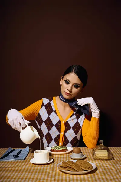 Uma jovem mulher em uma roupa elegante derrama creme em seu café em uma mesa para o café da manhã. — Fotografia de Stock