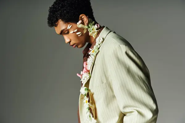 Young African American man in stylish striped blazer adorned with white flowers, exuding beauty and diversity. — Stock Photo