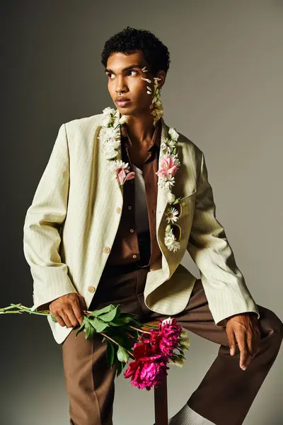 Um jovem afro-americano posa em um blazer elegante adornado com flores, mostrando beleza e diversidade. — Fotografia de Stock