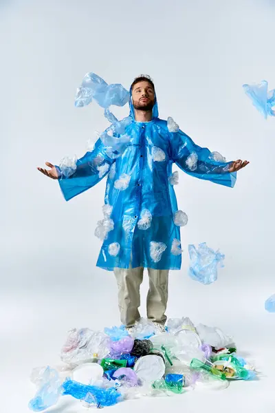 Um homem está em uma capa de chuva de plástico, cercado por detritos de plástico. — Fotografia de Stock