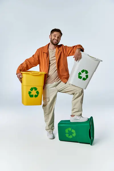 Ein Mann lächelt, während er mit einem Fuß auf einer grünen Tonne posiert. — Stockfoto