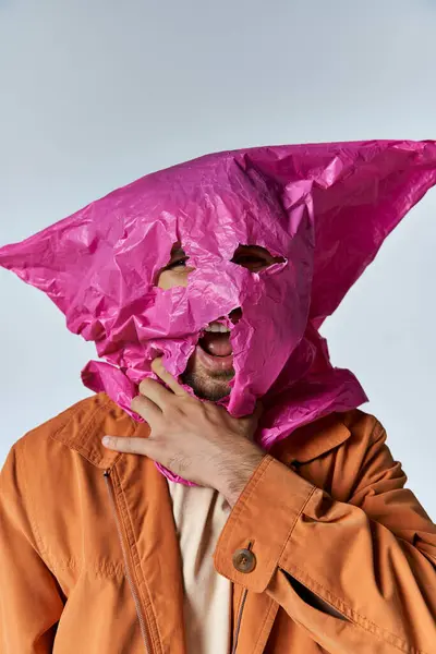 Un uomo con un sacchetto di plastica rosa sopra la testa. — Foto stock