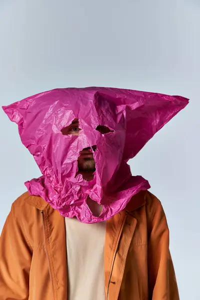 Um homem usando um saco de plástico rosa como máscara. — Fotografia de Stock