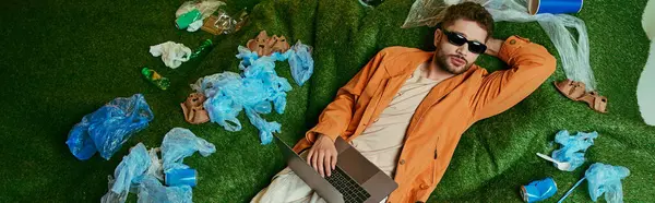A man relaxes on a lawn while surrounded by plastic waste. — Stock Photo