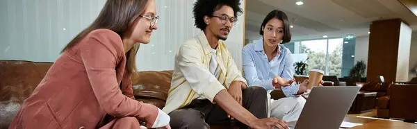Трое коллег общаются и работают на ноутбуке в офисном холле. — Stock Photo