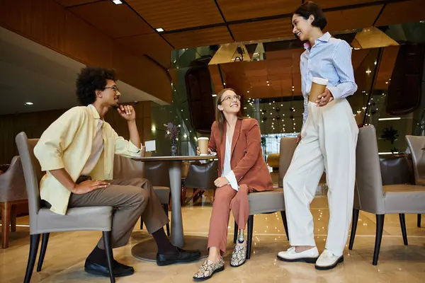 Multicultural colleagues enjoy a friendly conversation in a modern office setting. — Stock Photo