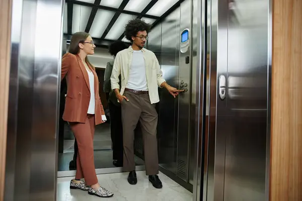 Deux collègues, l'un avec une prothèse de jambe, bavardent dans un ascenseur, attendant leur plancher. — Photo de stock