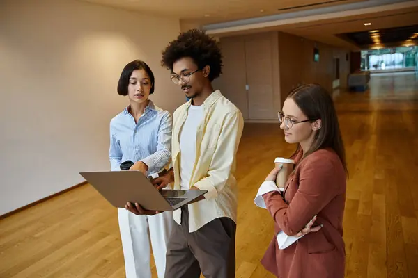 Drei Kollegen stehen in einem modernen Büroflur und besprechen die Arbeit. — Stockfoto