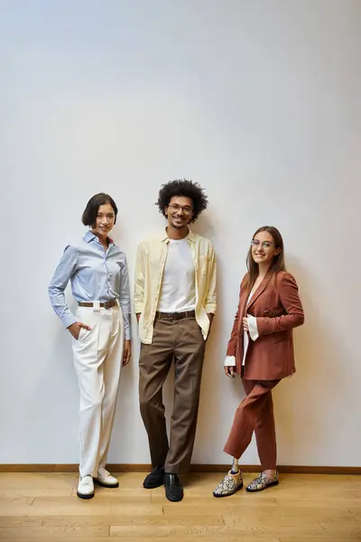 Three colleagues, including a woman with a prosthetic leg, stand in a modern office, smiling and chatting together. — Stock Photo