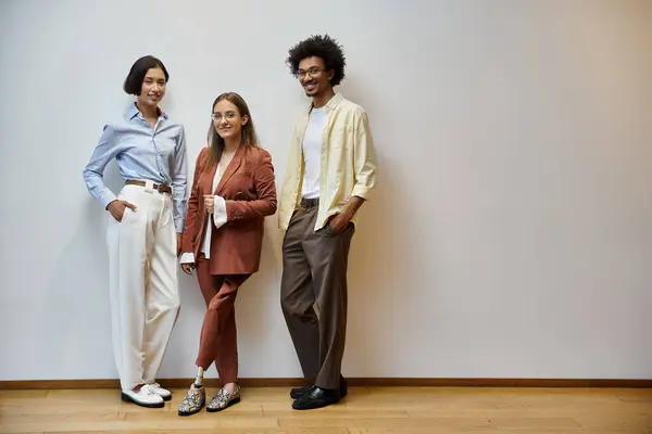Three colleagues stand together in a modern office, engaged in conversation. — Stock Photo