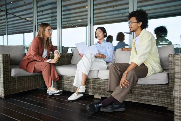 Interracial colleagues chat and collaborate on a modern office terrace. — Stock Photo